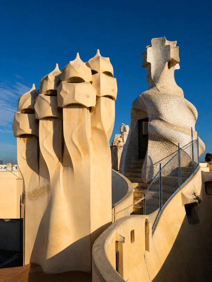 Twisted cream rooftop chimneys shaped like helmeted figures against a deep blue sky